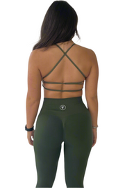 A woman modeling the Elite Collection - Cross Back Sports Bra in Khaki, showcasing its supportive cross back design.