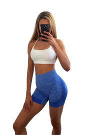 Kourtney Collection - Woman in blue shorts taking a selfie with a phone, showcasing gym wear for ultimate fitness comfort.