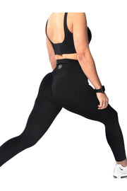 Woman in black scrunch butt gym leggings, high-waisted, enhancing shape, perfect for fitness routines.