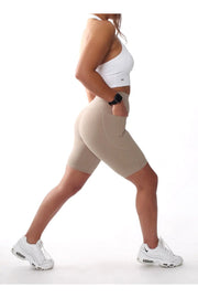 A woman wearing Embrace Collection seamless gym shorts with pockets, confidently ready for a workout.